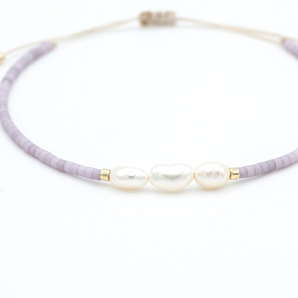 Armband mit kleinen Süßwasserperlen umrahmt von lilafarbigen und goldenen Miyuki Perlen