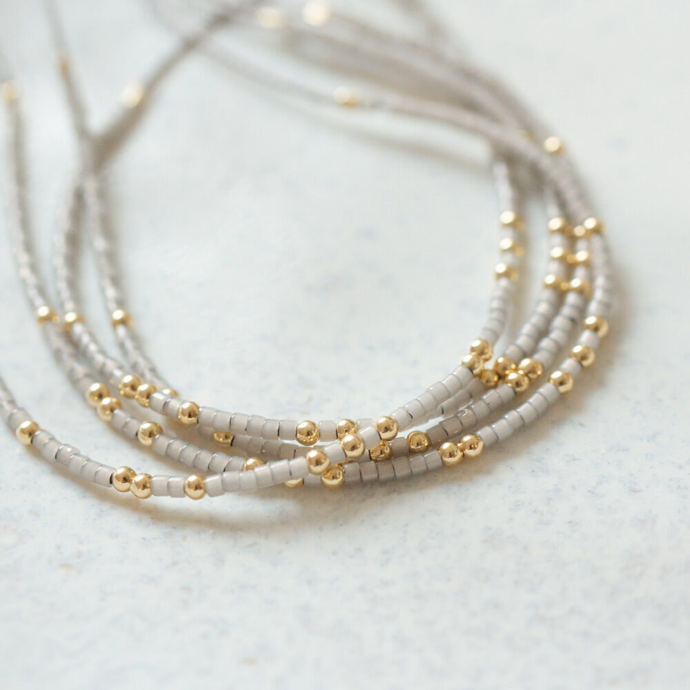 Armband mit grauen Miyuki Perlen und Goldperlen Detail
